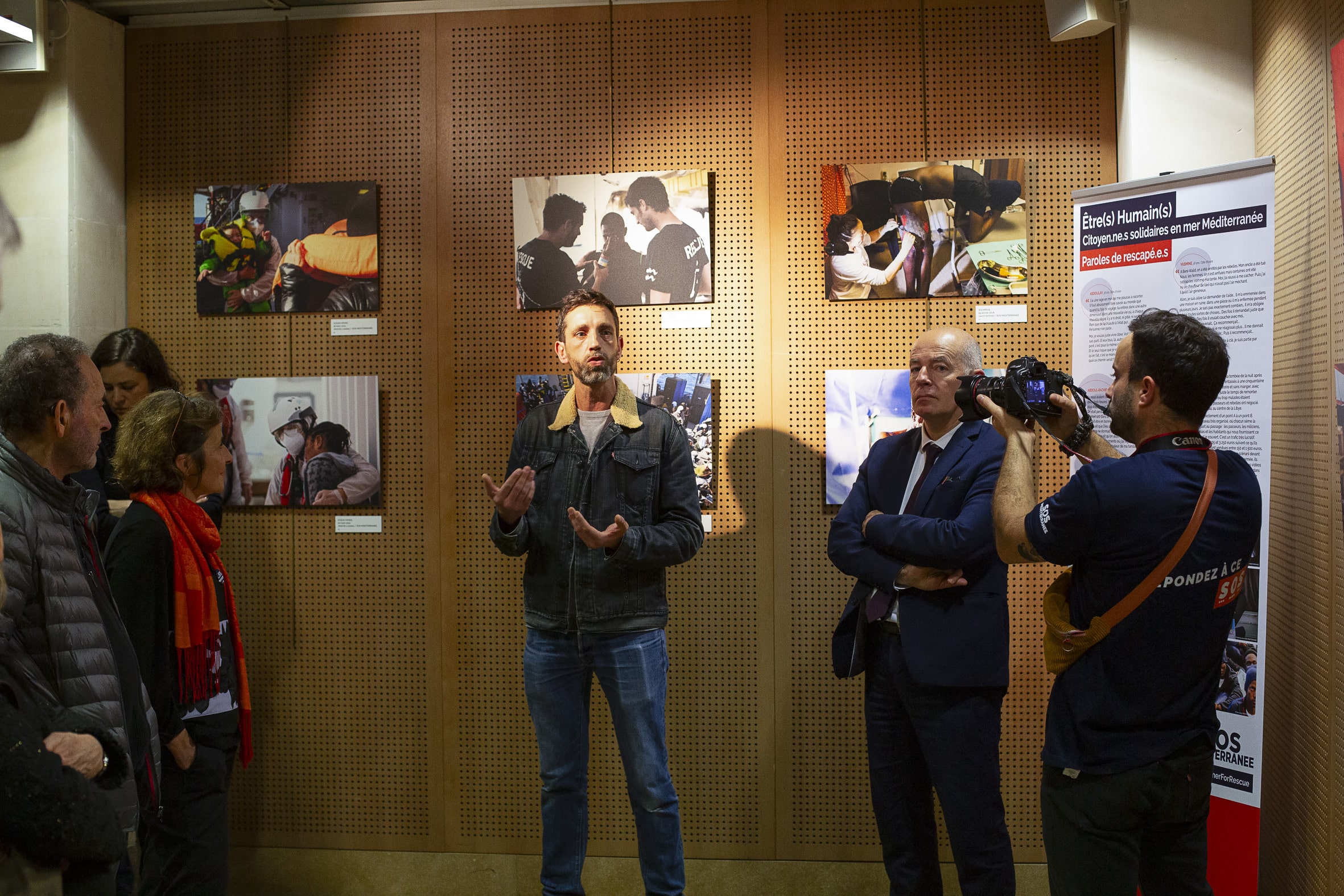 Jérémie Lusseau, photographe à bord, décrit ses clichés aux élu.e.s de Loire-Atlantique et au public venu assister à l'inauguration de l'expo